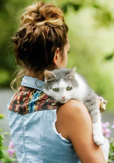 Frau hält katze im Arm